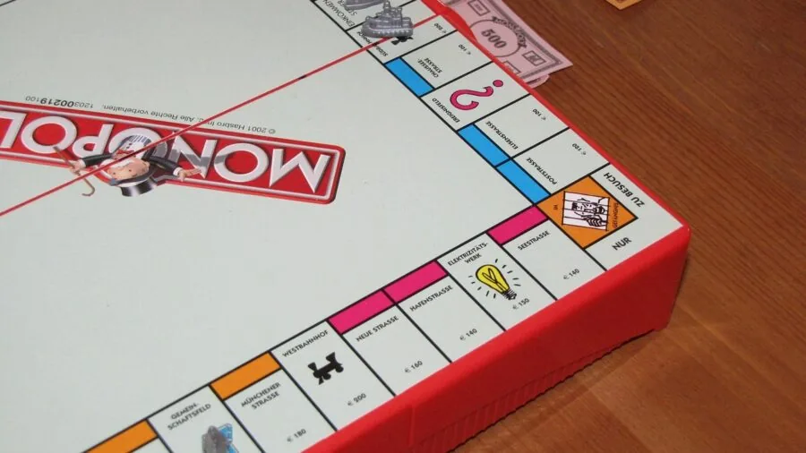 A diverse family of different ages gathered around a table playing board games indoors