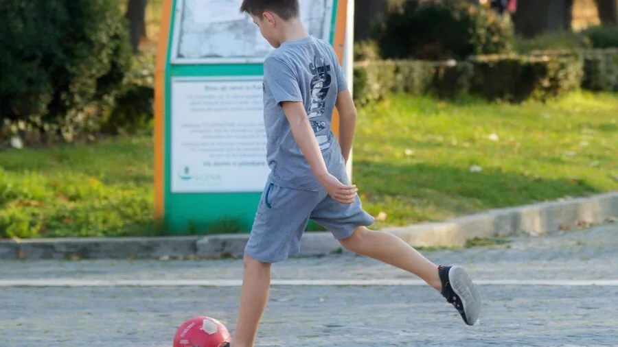 Active child running and playing on outdoor pavement surface