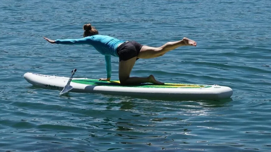Adult balancing on wooden board during home fitness training session