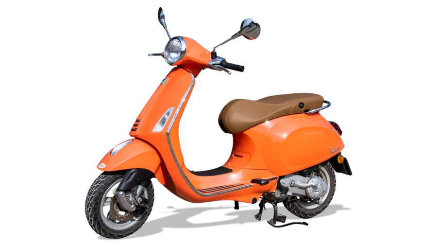 Adult carrying folded scooter while commuting through urban street