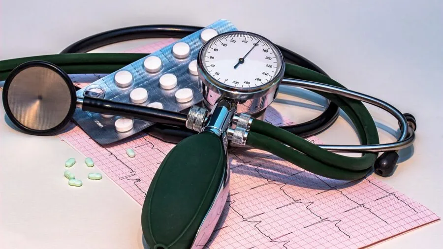 Adult measuring blood pressure during morning routine at home with medical monitor