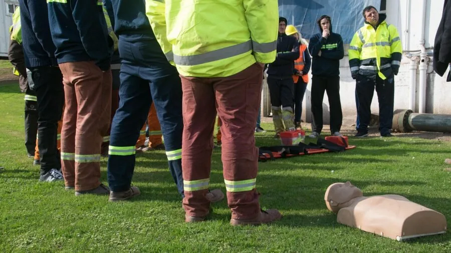 Adult practicing infant CPR technique on training dummy during first aid certification class