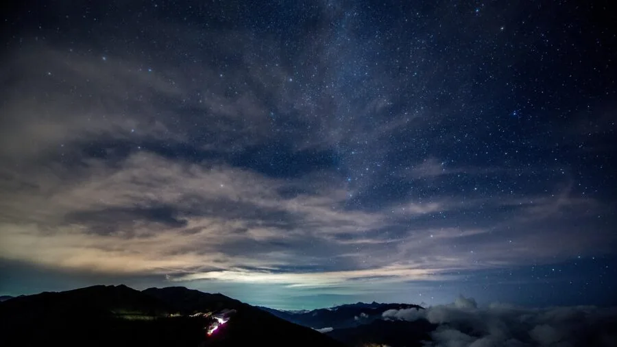Amateur astronomer observing stars through telescope on clear night under dark sky