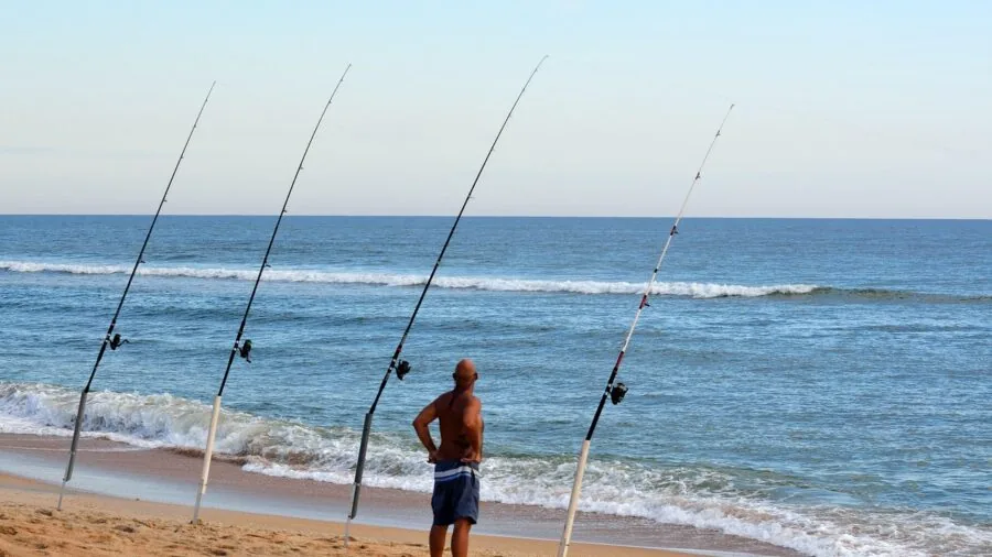 Angler fishing in saltwater ocean environment with casting rod during daytime