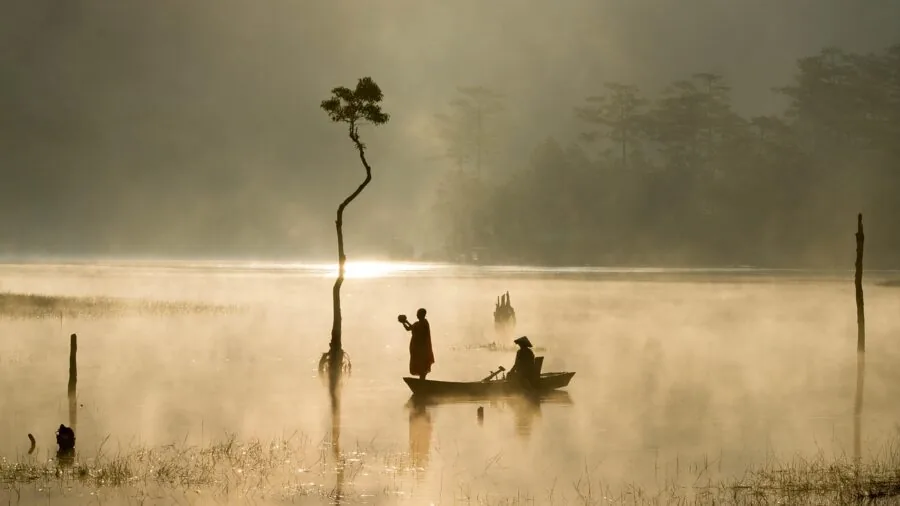 Angler wearing protective hat while fishing in bright sunlight on water