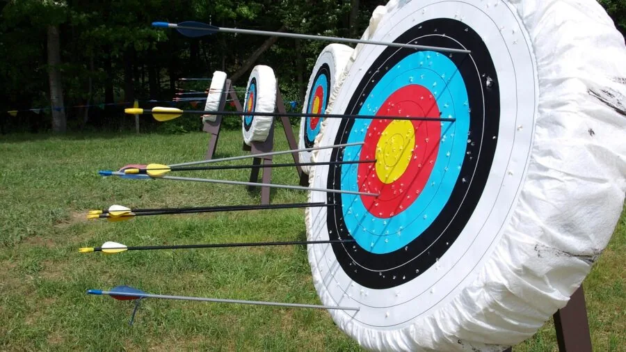 Archer in outdoor setting drawing recurve bow with focus and concentration during practice session