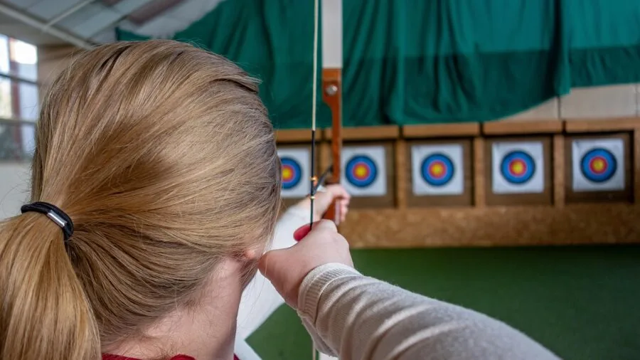Archer removing arrow from foam target during outdoor practice session