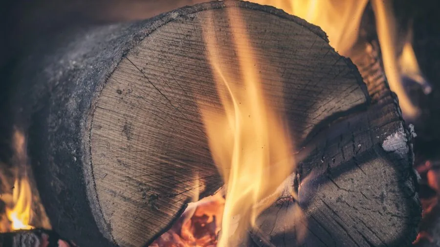 Artisan focused on detailed wood burning work with careful hand positioning and safety awareness