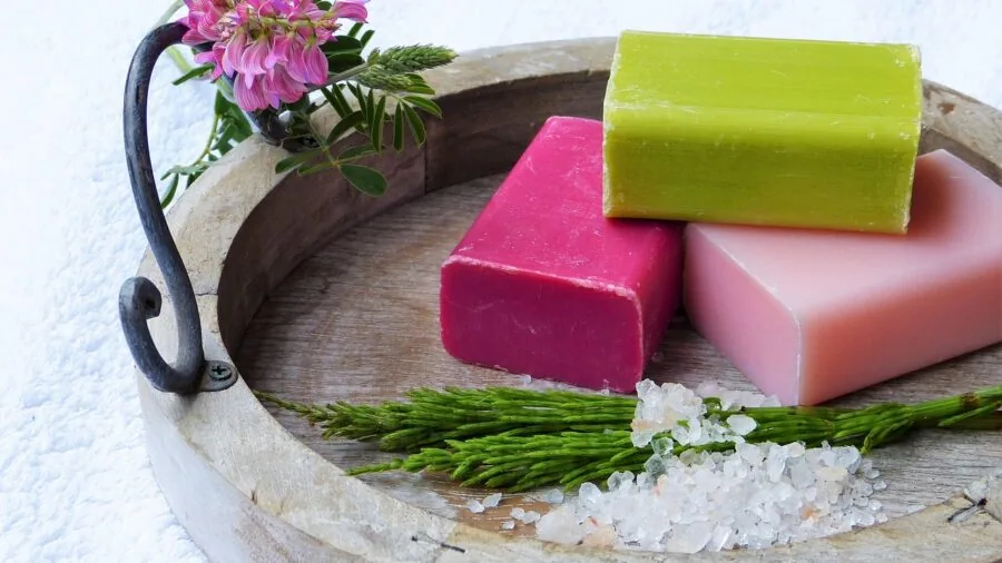 Artisan soap bars with botanical elements and natural colorants displayed in natural lighting