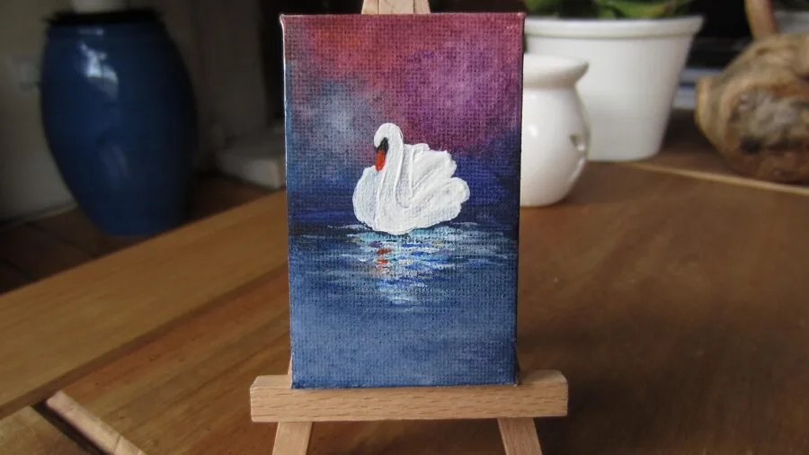 Artist applying acrylic paint to canvas in natural studio light