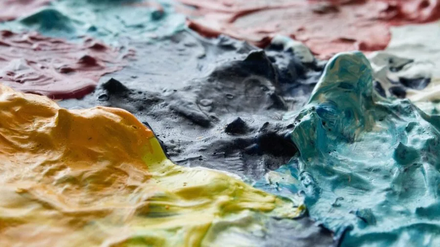 Artist applying thick acrylic paint with visible brushstrokes and texture on canvas