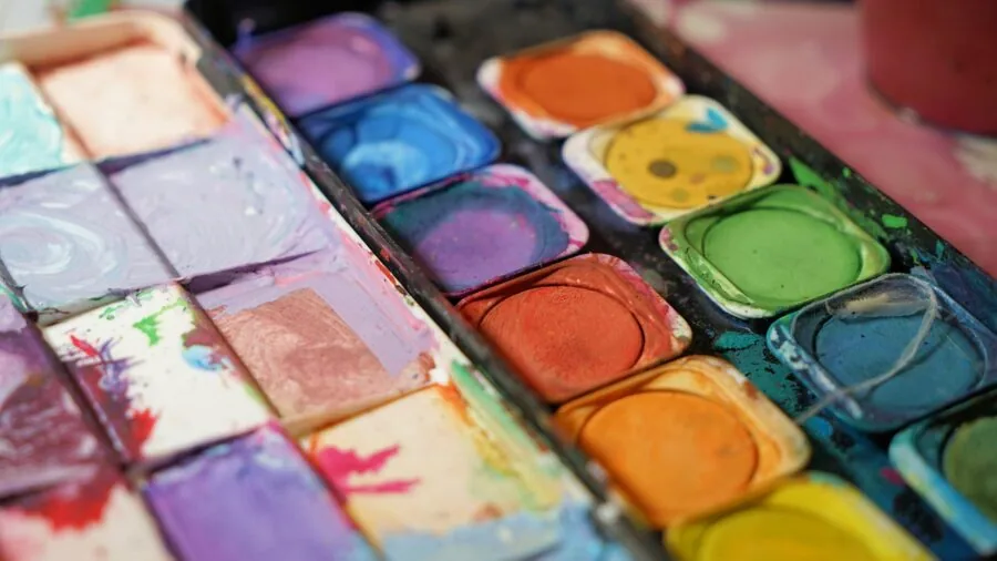 Artist arranging and selecting colorful markers while working on creative project at workspace