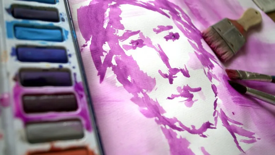 Artist concentrating while painting with watercolors at a natural light workspace