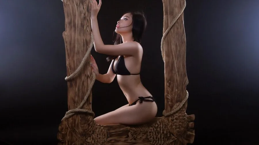 Artist examining wooden frame construction in natural studio lighting