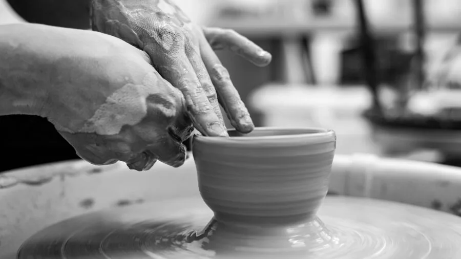 Artist hand-painting white air dry clay sculpture with acrylic paint in bright studio workspace
