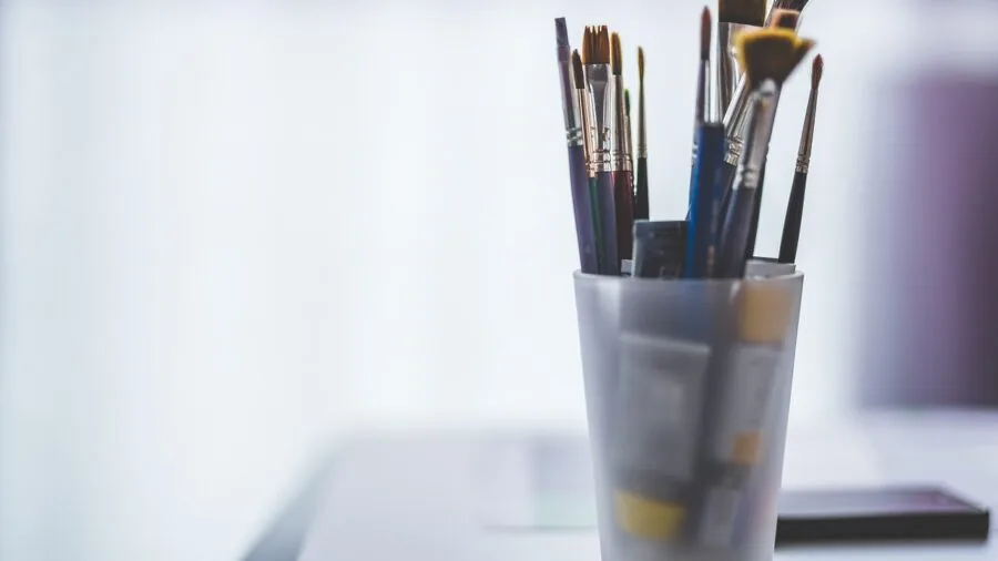 Artist painting outdoors with portable easel in natural setting