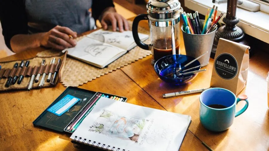 Artist sketching in open notebook outdoors in natural daylight