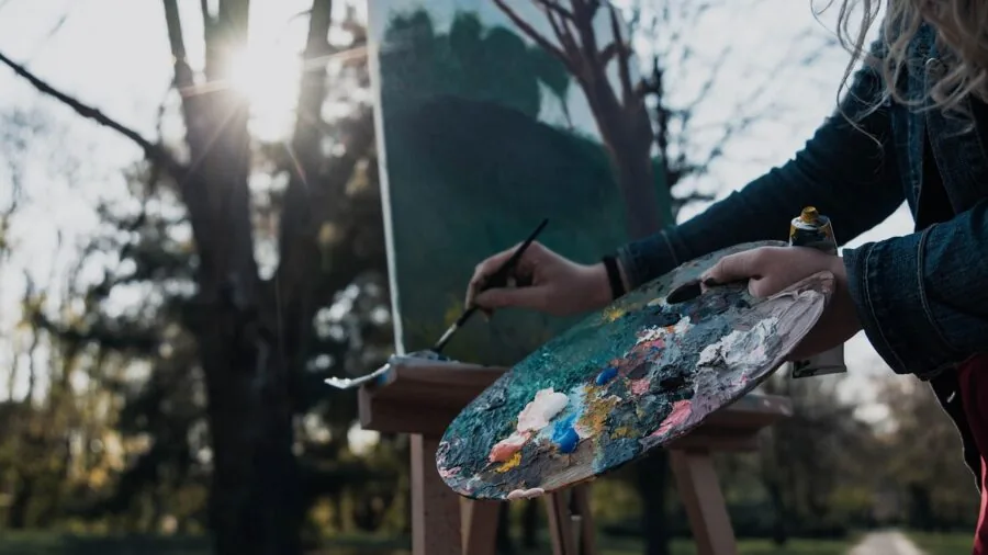 Artist sketching with watercolors at an outdoor cafe while traveling