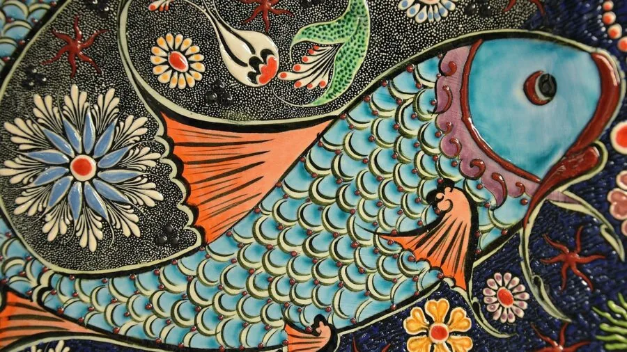 Artist's hands blending colored pencils on paper, creating layered color transitions in a natural workspace setting