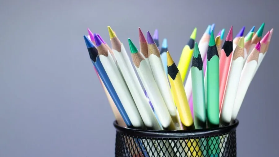Artist's hands blending colored pencils on paper during creative drawing session