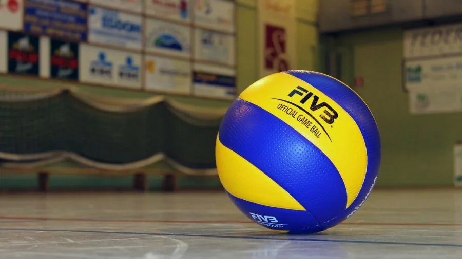 Athlete holding leather volleyball during indoor court practice session