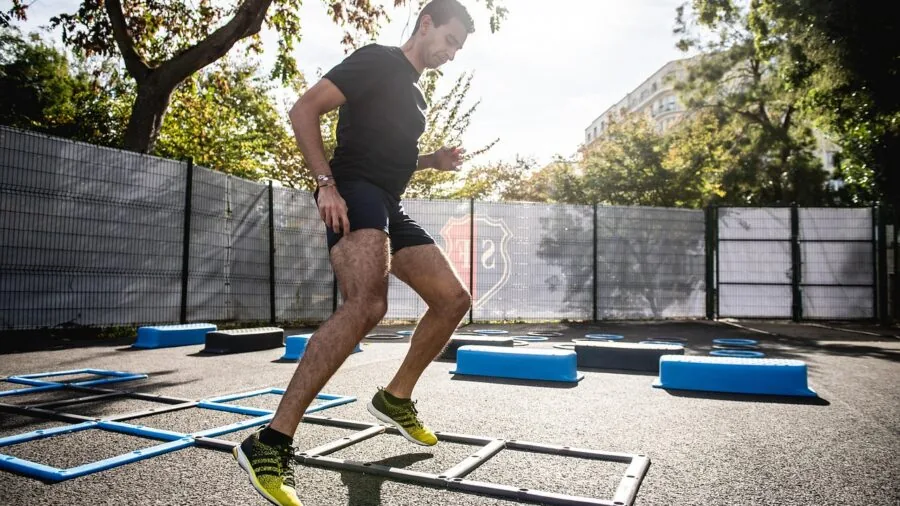 Athlete performing agility drills on outdoor field during fitness training session
