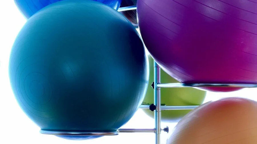 Athlete performing medicine ball bounce exercise during outdoor fitness training session