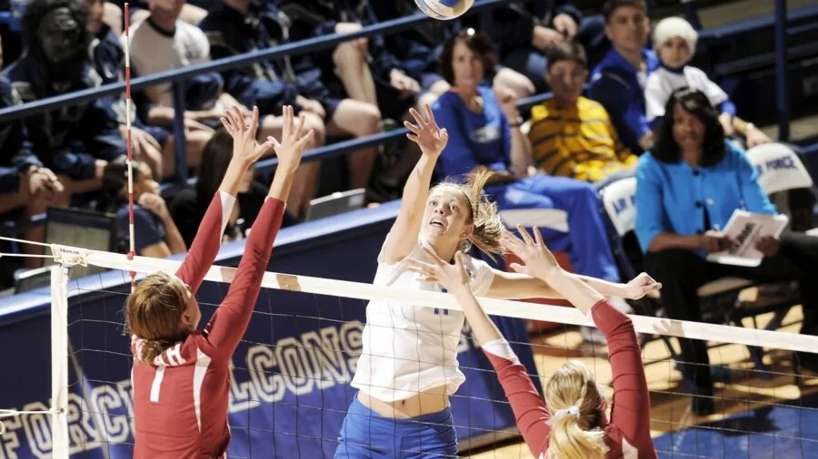 Athlete playing volleyball on indoor hardwood court during practice session