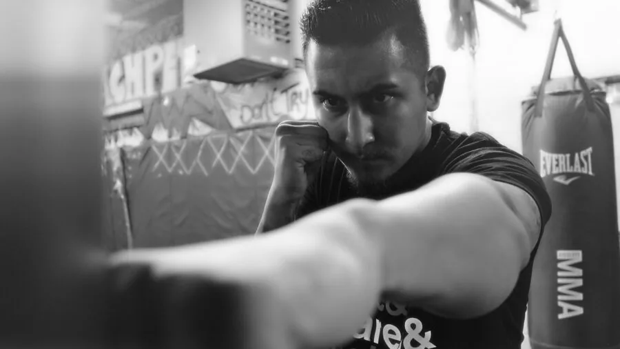 Athlete practicing with speed bag during boxing training session in gym
