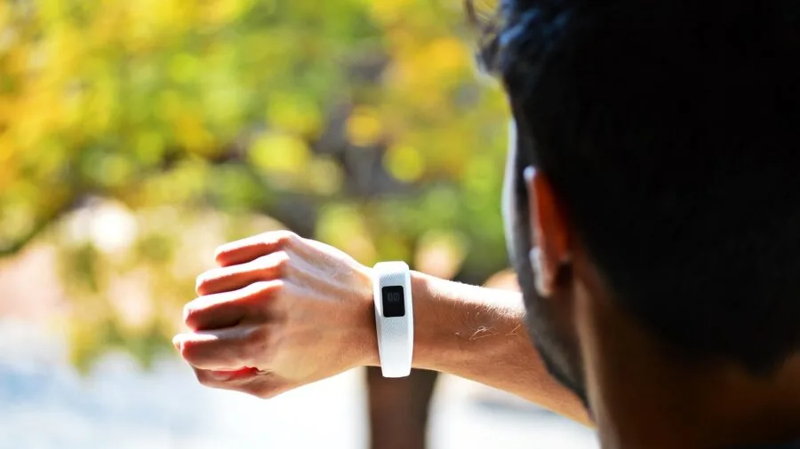 Athlete reviewing performance data on wrist device during outdoor running session