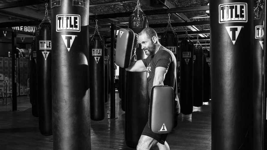 Athlete training with speed bag in gym, focused on hand-eye coordination and boxing technique