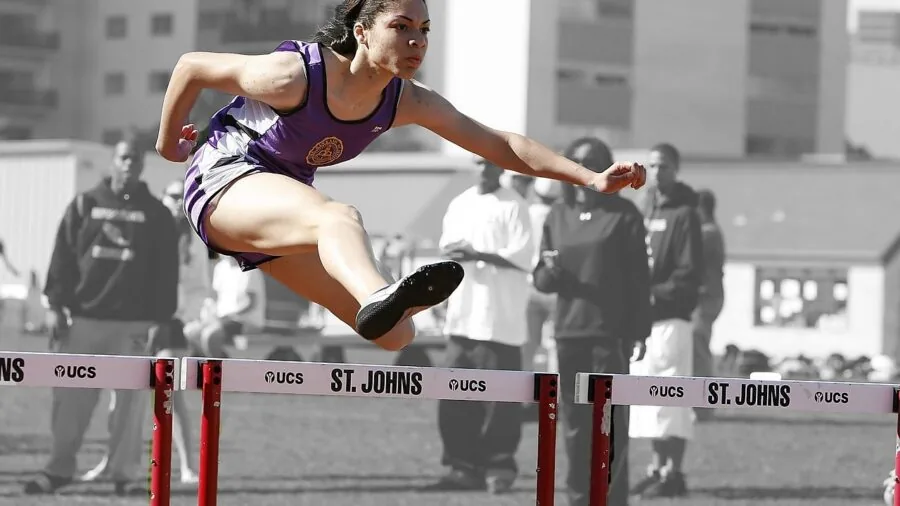 Athletic runner in motion on outdoor track during speed workout session