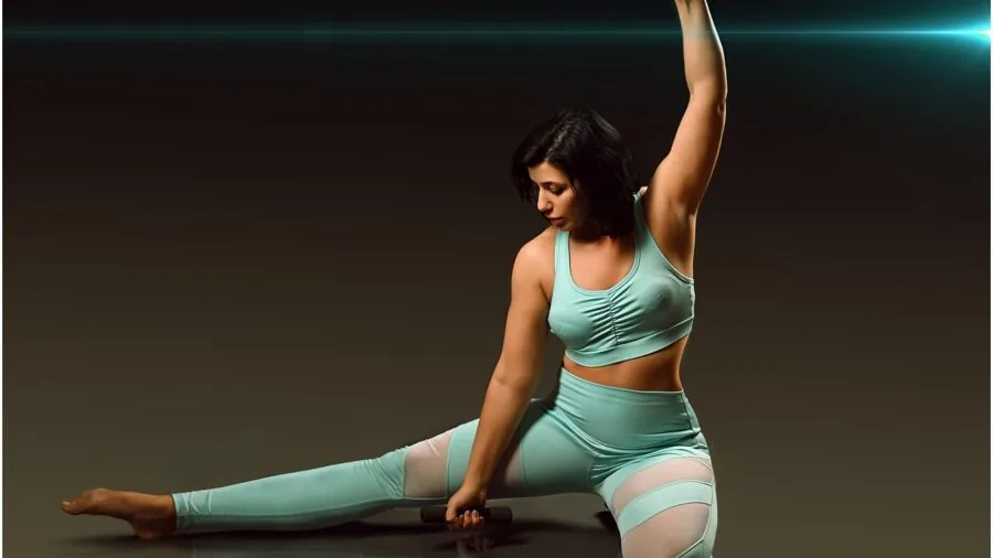 Athletic woman in sports bra stretching arms overhead before exercise session