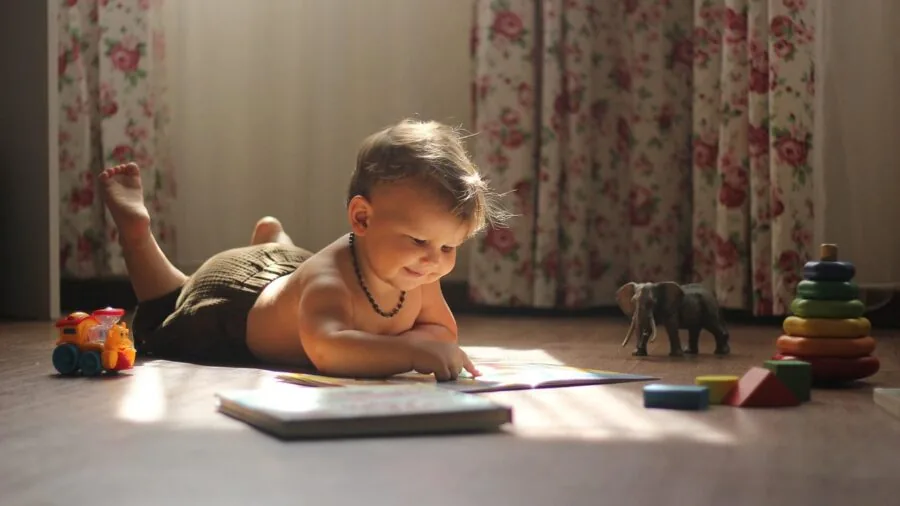 Baby exploring colorful musical toy with lights and textures during playtime on floor