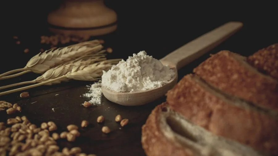 Baker carefully measuring dry ingredients with measuring cups for accurate recipe proportions