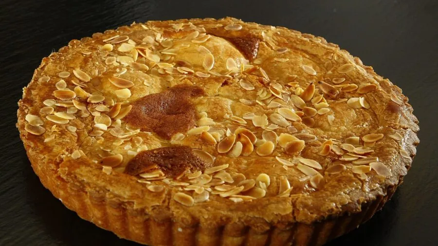 Baker opening oven door to check baking cake, examining even browning and rise