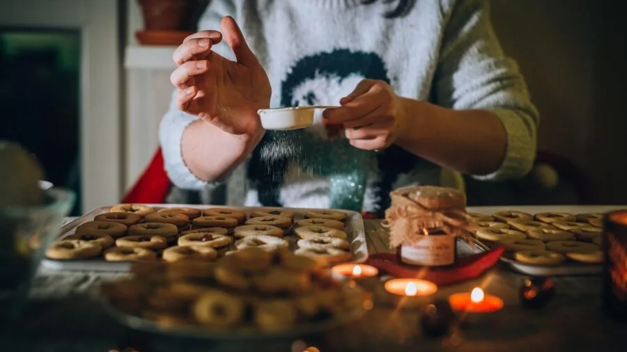 Baker preparing diverse desserts in a bright, well-lit kitchen with various baking tools and ingredients visible