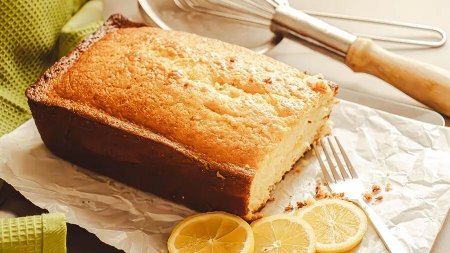 Baker removing freshly baked cheesecake from springform pan in bright kitchen