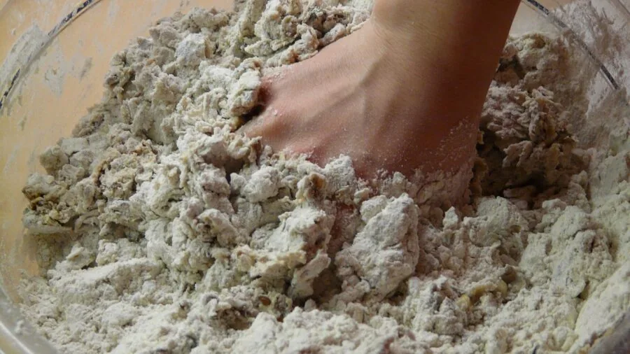 Baker's hands working with dough near warm kitchen light, showing the craft of baking