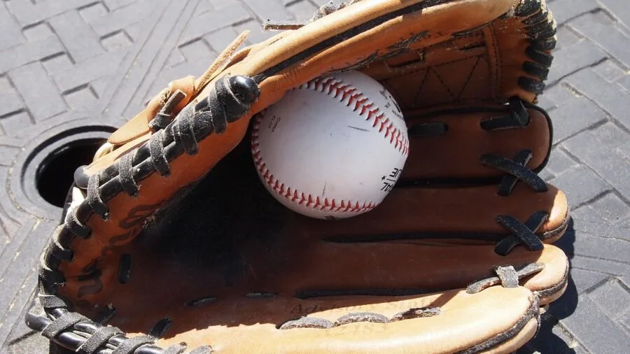 Baseball player checking glove fit and comfort before batting practice