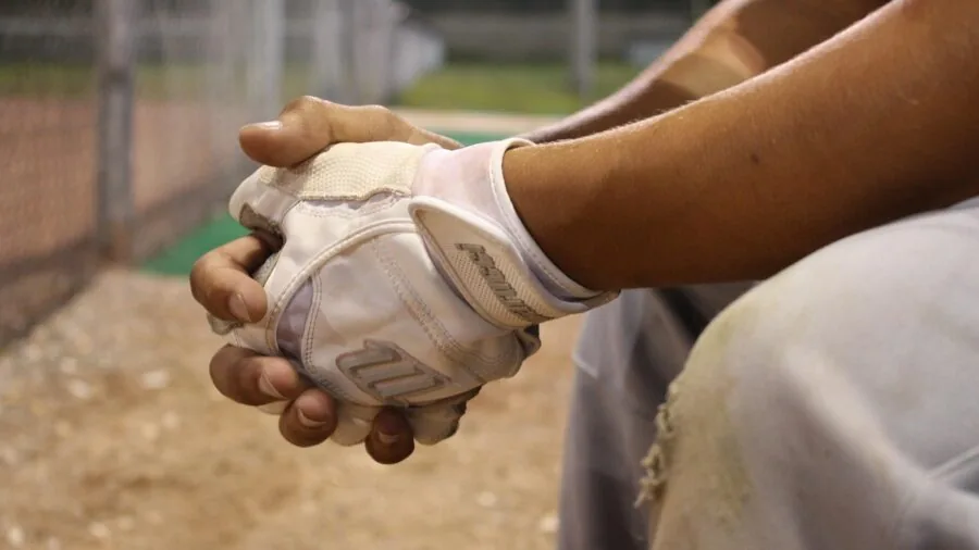 Baseball player gripping bat during batting practice, showing hand positioning and grip technique
