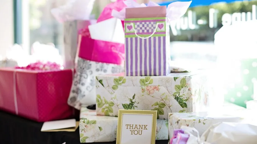 Beautifully wrapped baby shower gift with soft ribbon and decorative wrapping paper on neutral background