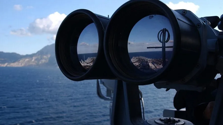 Birdwatcher observing wildlife with binoculars in natural outdoor setting