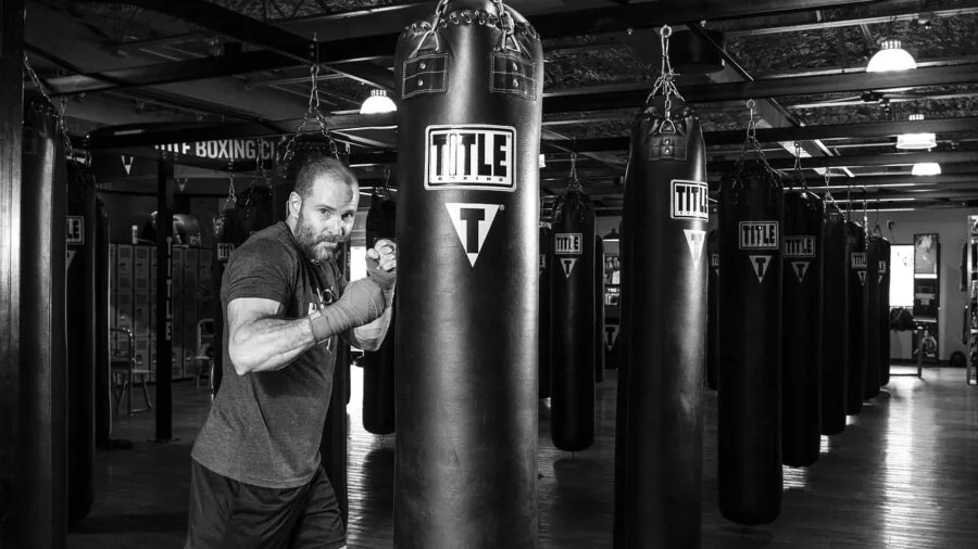 Boxer practicing combination punches on heavy bag with focused form and stance