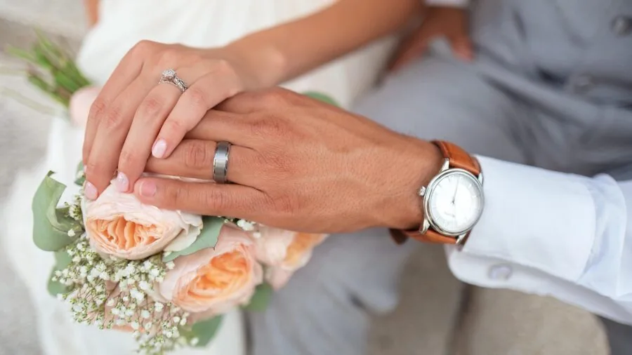 Bride displaying stacked wedding bands on her hand in natural lighting