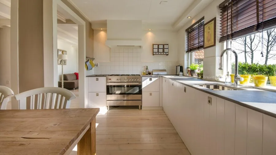 Bright modern kitchen with open layout showing appliance placement and storage organization