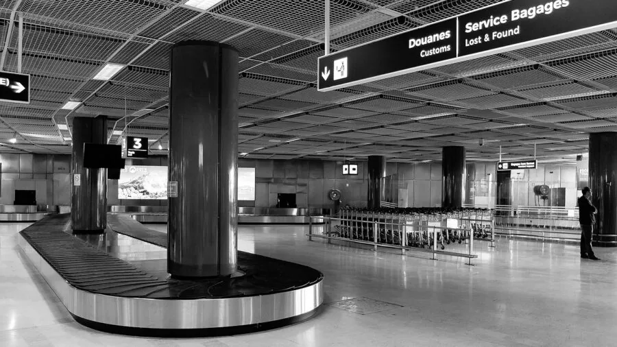 Business traveler navigating airport with compact wheeled carry-on luggage