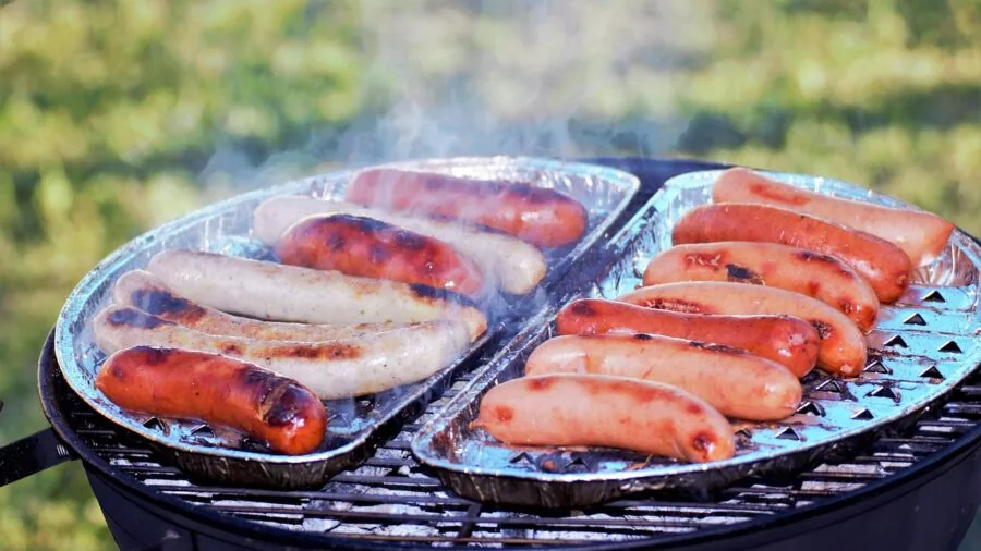 Campers preparing food on outdoor table in natural setting