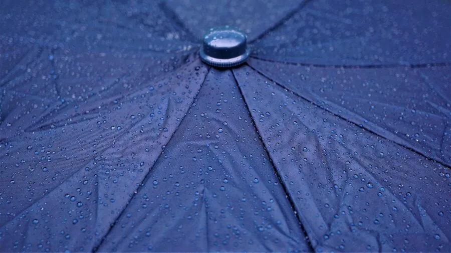 Car covered in rain during stormy weather, demonstrating weatherproofing and protection