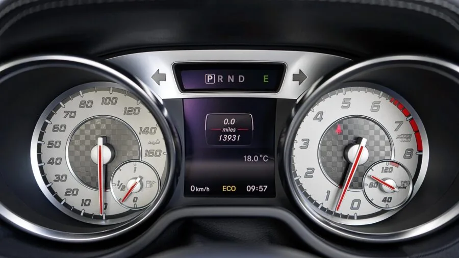 Car dashboard display showing battery indicator and power status during daytime driving